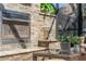 Outdoor fireplace and sitting area with stone accents and glass table with comfortable chairs at 1956 Brantley Cir, Clermont, FL 34711