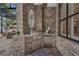 Outdoor kitchen with brick accent wall and stainless steel grill, mini fridge, and sink for seamless entertaining at 1956 Brantley Cir, Clermont, FL 34711