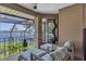 Relaxing screened patio featuring lake views, comfortable lounge chairs, and beautiful plants at 1956 Brantley Cir, Clermont, FL 34711