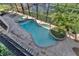 Aerial view of a backyard pool and spa featuring a screened enclosure, lush landscaping, and brick pavers at 1956 Brantley Cir, Clermont, FL 34711