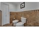 Elegant powder room features marble-style tile walls, a bidet, toilet and decorative wall art at 1956 Brantley Cir, Clermont, FL 34711
