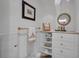 Charming powder room featuring decorative mirror, elegant gold accents, and a cute 'hello' sign on built-in shelving at 1956 Brantley Cir, Clermont, FL 34711