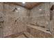 Luxurious walk-in shower boasts beautiful marble-style tile, multiple shower heads, and a convenient built-in bench at 1956 Brantley Cir, Clermont, FL 34711