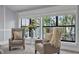 Cozy sitting area with armchairs, decorative pillows, and large windows overlooking a serene lake view at 1956 Brantley Cir, Clermont, FL 34711