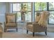 Sitting room with two gray upholstered chairs, a small side table, and decorative pillows at 1956 Brantley Cir, Clermont, FL 34711