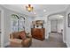 Bright sitting room with a small water view from the arched windows and an arched doorway at 1956 Brantley Cir, Clermont, FL 34711