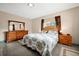 Spacious bedroom with wood furniture, a floral comforter, and dual windows for natural light at 2007 Mosher Dr, Orlando, FL 32810