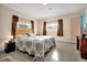 Well-lit bedroom with a floral comforter, neutral walls, and dual windows for natural light at 2007 Mosher Dr, Orlando, FL 32810