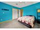 Vibrant bedroom with blue walls, terrazzo flooring, and a comfortable bed with quilt at 2007 Mosher Dr, Orlando, FL 32810
