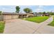 Inviting ranch-style home with a two-car garage, American flag, and a well-maintained lawn at 2007 Mosher Dr, Orlando, FL 32810