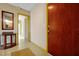 Neutral-toned hallway with a front door, interior doors, a mirror, and a patterned linoleum floor at 2007 Mosher Dr, Orlando, FL 32810