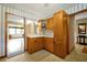 Bright kitchen with hardwood cabinets and a view into the living room at 2007 Mosher Dr, Orlando, FL 32810