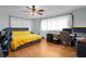 Bright bedroom with hardwood floors, a ceiling fan, and a comfortable bed under large windows at 2022 Edgewood Rd, Leesburg, FL 34748