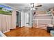 Cozy bedroom featuring hardwood floors, a playful house bed, and a ceiling fan for added comfort at 2022 Edgewood Rd, Leesburg, FL 34748