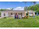Single story home featuring a well-maintained lawn and colorful outdoor play equipment at 2022 Edgewood Rd, Leesburg, FL 34748