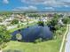 Aerial view of a neighborhood, featuring a tranquil lake and well-maintained green spaces at 2104 Winding Ridge S Ave, Kissimmee, FL 34741