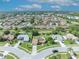 Aerial view of a residential neighborhood featuring a house with a well-manicured lawn and mature trees at 2104 Winding Ridge S Ave, Kissimmee, FL 34741