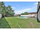 Backyard with in-ground pool, large grassy area, and shed, creating a private oasis at 2104 Winding Ridge S Ave, Kissimmee, FL 34741