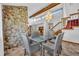 Open dining area featuring stone wall accent and modern chandelier that creates a warm and sophisticated ambiance at 2104 Winding Ridge S Ave, Kissimmee, FL 34741