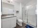 Bathroom with white vanity, sink, toilet and a walk-in shower with glass door and a blue rug at 2142 Weber Ct, The Villages, FL 32163