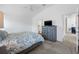 Bedroom featuring a bed, ceiling fan, dresser with TV and access to the bathroom at 2142 Weber Ct, The Villages, FL 32163
