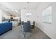 Bright dining area with modern chandelier, stylish table, and chairs, open to the living room and kitchen at 2142 Weber Ct, The Villages, FL 32163