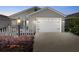 Charming gray home with a white garage door, white picket fence, and a cozy screened-in porch at 2142 Weber Ct, The Villages, FL 32163