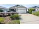 Charming gray home with a white garage door, manicured landscaping and a cozy screened-in porch at 2142 Weber Ct, The Villages, FL 32163