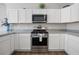 Well-equipped kitchen featuring modern oven, white cabinets, and sleek countertops at 2142 Weber Ct, The Villages, FL 32163