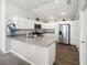 Modern kitchen with white cabinets, stainless steel appliances, and a breakfast bar area at 2142 Weber Ct, The Villages, FL 32163