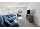 Bright living room features plush seating, a glass table, and a modern entertainment center at 2142 Weber Ct, The Villages, FL 32163