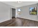 Bright bedroom featuring wood flooring, a closet, and three large windows overlooking the yard at 2235 Harbor Town Ln, Lakeland, FL 33810