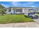 Beautiful one story home with a green lawn and a golf cart in the driveway at 2235 Harbor Town Ln, Lakeland, FL 33810