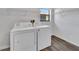 Functional laundry room with washer, dryer, overhead shelving, and a window at 2235 Harbor Town Ln, Lakeland, FL 33810