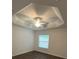 Bright bedroom features a tray ceiling with fan and a window allowing for natural light at 2441 Nellie Rd, The Villages, FL 32163