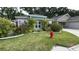 Charming home exterior with lush landscaping, a well-manicured lawn, and classic architectural details at 2441 Nellie Rd, The Villages, FL 32163