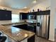 Modern kitchen featuring dark cabinets, stainless steel appliances, and a breakfast bar at 2441 Nellie Rd, The Villages, FL 32163