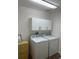 Laundry room with a washer, dryer, upper cabinets and wood flooring at 2441 Nellie Rd, The Villages, FL 32163