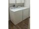 Close-up shot of the laundry room with a washer, dryer and wood flooring at 2441 Nellie Rd, The Villages, FL 32163