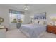 Bright bedroom featuring a comfortable bed, bedside tables, and a large window with natural light at 2738 Morven Park Way, The Villages, FL 32162