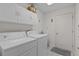 Convenient laundry room featuring washer, dryer, and upper cabinets at 2738 Morven Park Way, The Villages, FL 32162