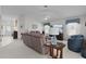 Open-concept living room with comfortable furniture, a large TV, and neutral décor and open to a dining room at 2738 Morven Park Way, The Villages, FL 32162