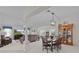 Spacious living room with neutral décor, a dining area, large windows, and a view of the lush landscaping at 2738 Morven Park Way, The Villages, FL 32162