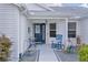 Cozy front porch with seating, a rocking chair, and a decorative door with a welcome sign at 2738 Morven Park Way, The Villages, FL 32162