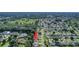 Aerial view of community with lush green spaces; subject property indicated by red arrow at 2766 Privada Dr, The Villages, FL 32162