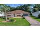 Charming home featuring a well-manicured lawn, brick driveway, and a cozy, inviting entrance at 2766 Privada Dr, The Villages, FL 32162