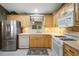 Galley kitchen featuring stainless steel appliances, tiled backsplash, and bright lighting at 2766 Privada Dr, The Villages, FL 32162