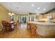 Open-concept kitchen and dining area featuring a tiled bar, wood cabinets, and a bright, airy atmosphere at 2766 Privada Dr, The Villages, FL 32162