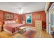 An interior of the main bedroom with red walls and wooden floors at 2766 Privada Dr, The Villages, FL 32162