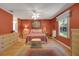 An interior of the main bedroom features a ceiling fan and bright red walls at 2766 Privada Dr, The Villages, FL 32162
